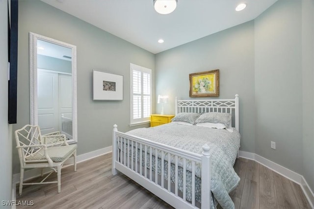 bedroom with recessed lighting, wood finished floors, and baseboards