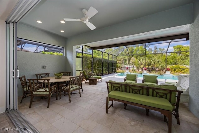 view of patio / terrace featuring a lanai, an outdoor pool, outdoor dining space, and a ceiling fan