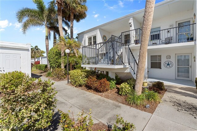 755 Village Cir Unit 203, Venice, FL 34292 - view of side of property with stucco siding and stairway