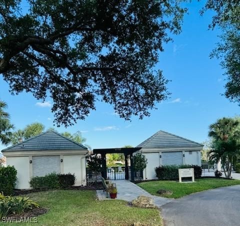 12713 Devonshire Lakes Dr, Fort Myers, FL 33913 - ranch-style home with a front lawn, stucco siding, an outdoor structure, and fence