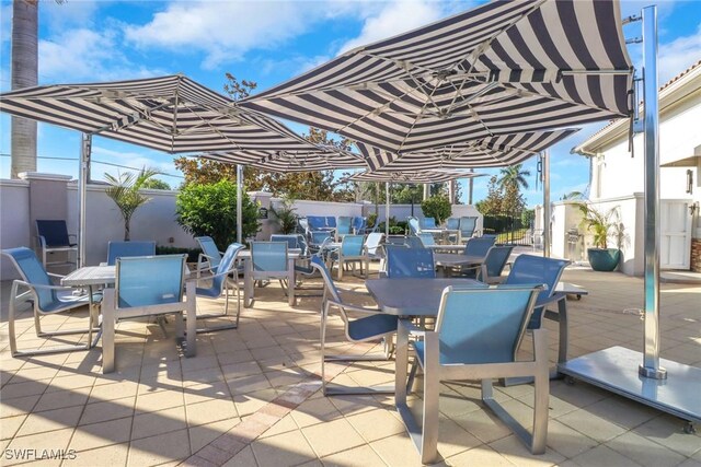 11384 Quail Village Way Unit 201, Naples, FL 34119 - fenced backyard with outdoor dining area and a patio area