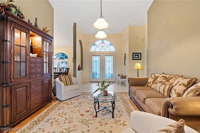 living room with french doors, a high ceiling, and baseboards