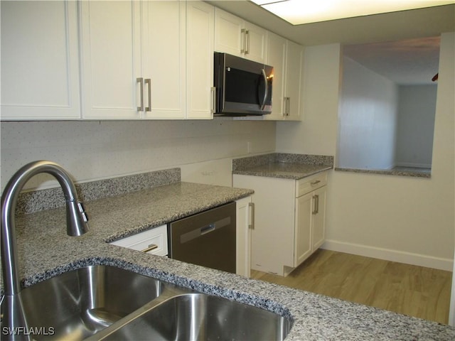 kitchen featuring a sink, light wood-style floors, appliances with stainless steel finishes, and white cabinets