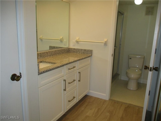 full bathroom featuring visible vents, toilet, a stall shower, wood finished floors, and vanity