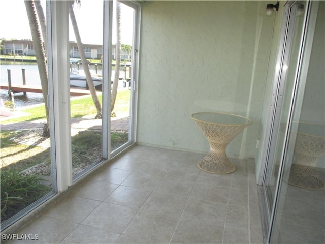 unfurnished sunroom with a water view