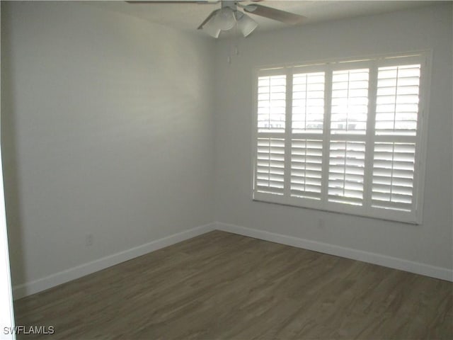 spare room with baseboards, wood finished floors, and a ceiling fan