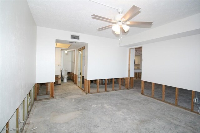 spare room with visible vents, unfinished concrete flooring, a textured ceiling, and ceiling fan
