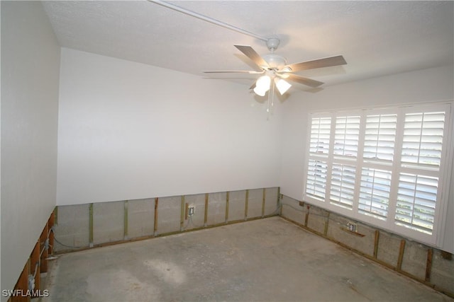 unfurnished room featuring a healthy amount of sunlight, concrete floors, and ceiling fan