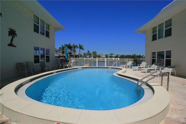 community pool featuring a patio and fence