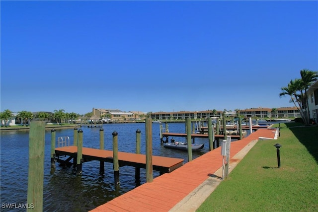 dock area featuring a water view, boat lift, and a lawn