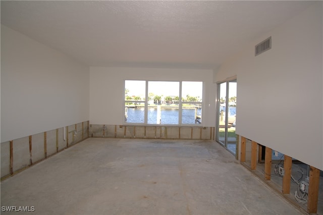 unfurnished room featuring visible vents and a water view