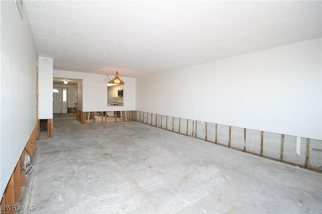 empty room with unfinished concrete flooring and a textured ceiling