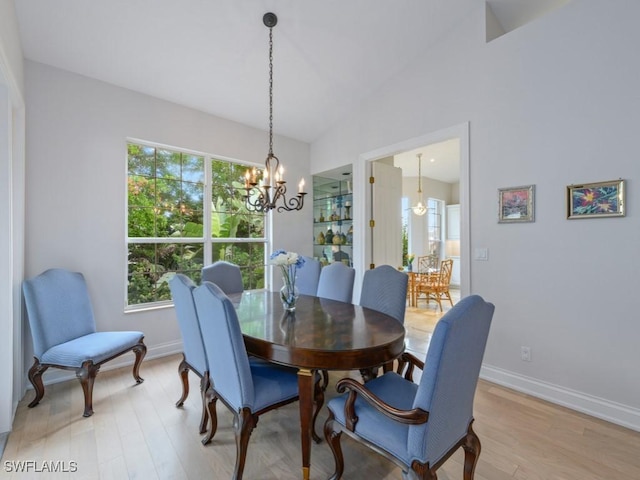 265 Colonade Cir, Naples, FL 34103 - dining area featuring baseboards, light wood-style floors, a chandelier, and vaulted ceiling