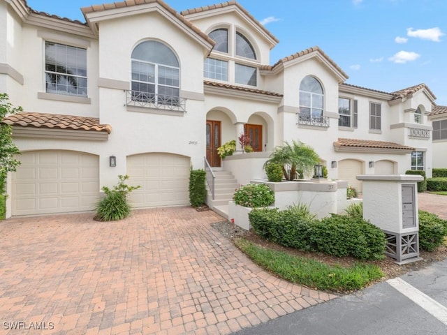 265 Colonade Cir, Naples, FL 34103 - mediterranean / spanish-style house featuring stucco siding, an attached garage, a tile roof, and decorative driveway