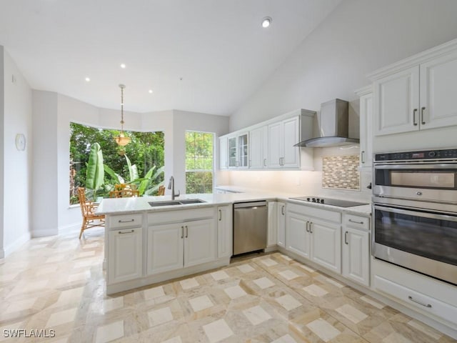 265 Colonade Cir, Naples, FL 34103 - kitchen with wall chimney range hood, light countertops, appliances with stainless steel finishes, a peninsula, and a sink