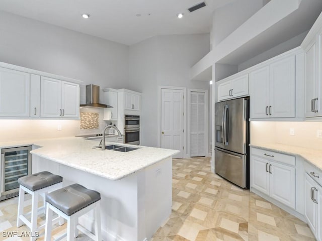 265 Colonade Cir, Naples, FL 34103 - kitchen featuring visible vents, beverage cooler, appliances with stainless steel finishes, white cabinets, and wall chimney exhaust hood