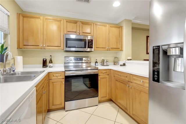 kitchen with crown molding, light countertops, light tile patterned floors, appliances with stainless steel finishes, and a sink