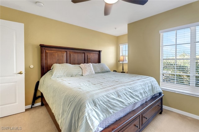 bedroom featuring baseboards, light colored carpet, and a ceiling fan