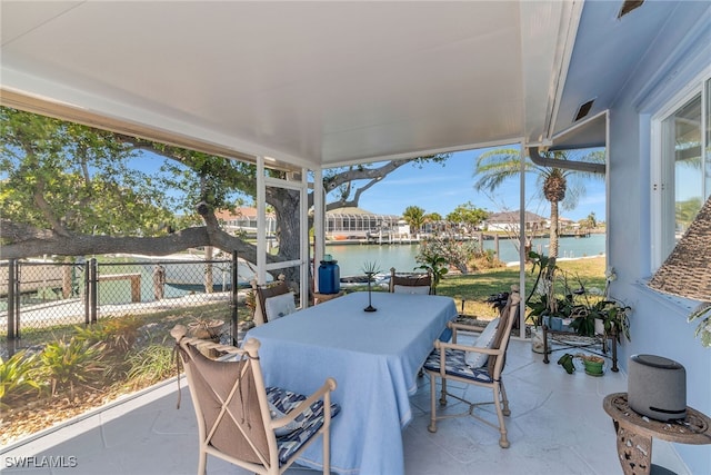 view of patio / terrace featuring outdoor dining space, fence, and a water view