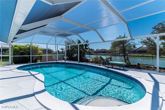 pool with a patio, a water view, and a lanai