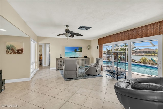 living room with visible vents, baseboards, light tile patterned flooring, and a ceiling fan