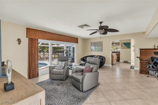 living area featuring visible vents, baseboards, light tile patterned flooring, and a ceiling fan