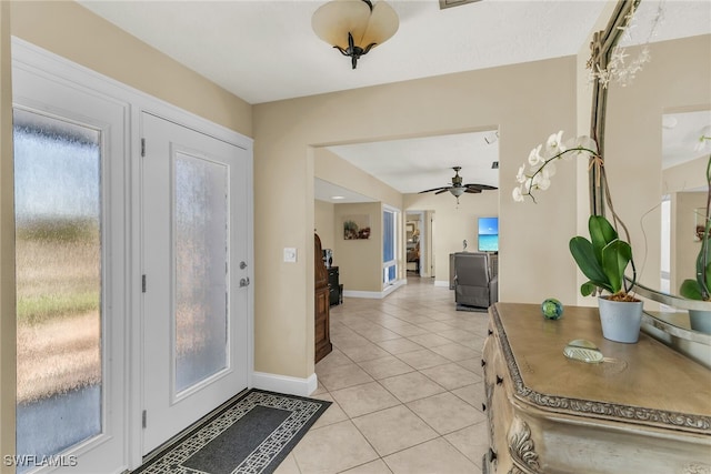 foyer featuring light tile patterned floors, a ceiling fan, and baseboards