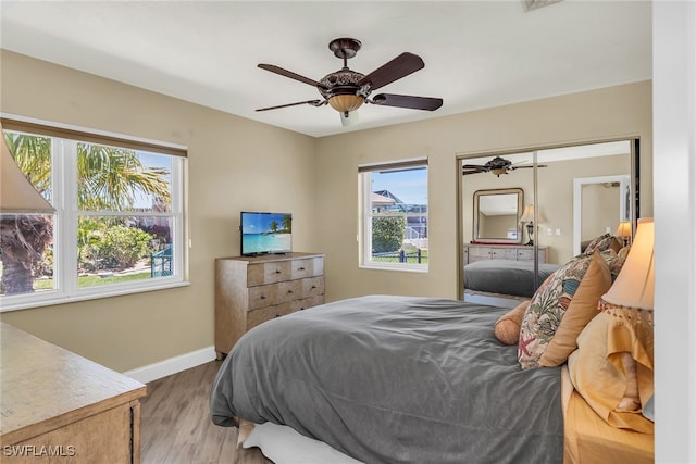 bedroom with a ceiling fan, wood finished floors, and baseboards