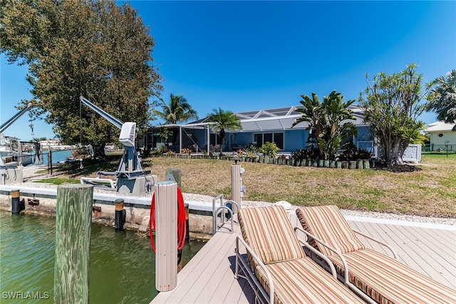 view of dock featuring glass enclosure, a yard, and a water view