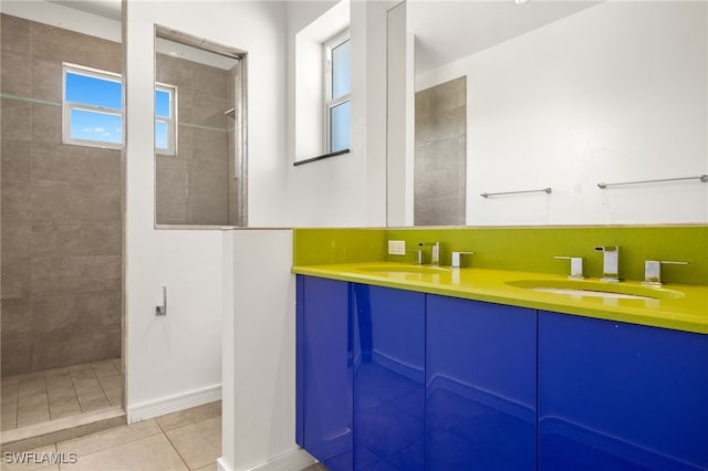 full bath featuring double vanity, tile patterned flooring, a walk in shower, and a sink