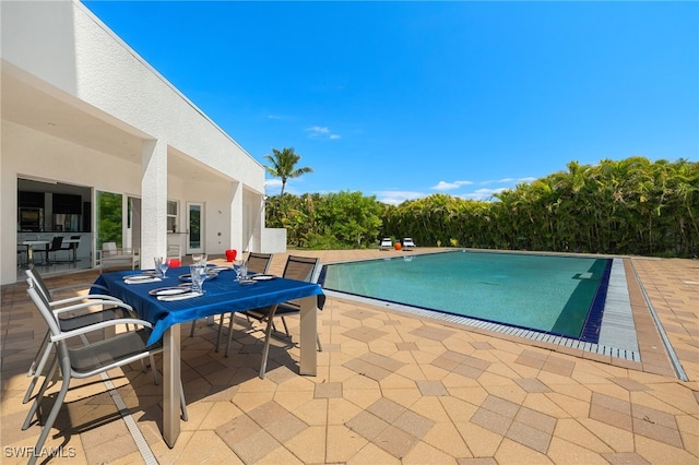 outdoor pool featuring outdoor dining area and a patio area