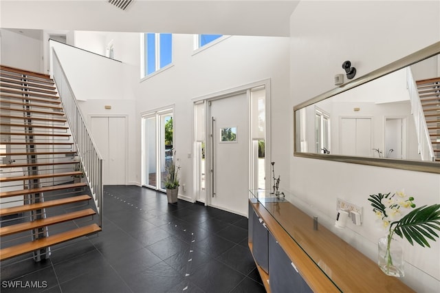 foyer with visible vents, a high ceiling, and stairs