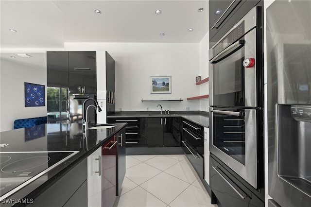 kitchen with light tile patterned flooring, appliances with stainless steel finishes, modern cabinets, and a sink