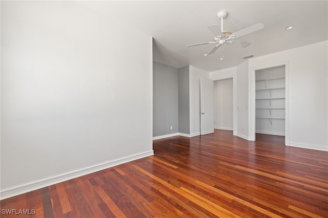 unfurnished room with built in features, a ceiling fan, visible vents, baseboards, and wood-type flooring