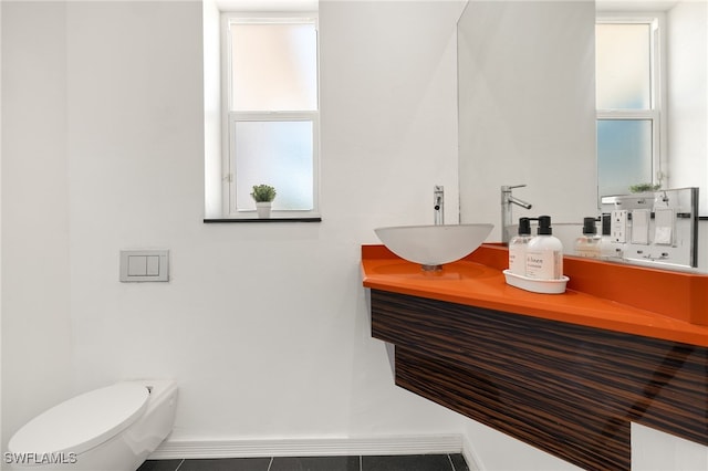 bathroom with toilet, baseboards, and a sink