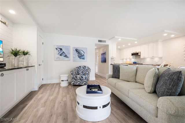 living area featuring recessed lighting, visible vents, baseboards, and light wood finished floors
