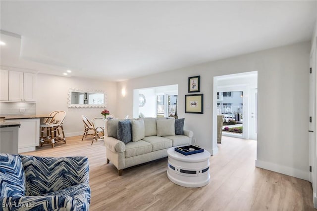 living room featuring recessed lighting, baseboards, and light wood-style floors