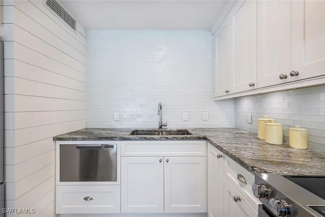 kitchen with tasteful backsplash, visible vents, appliances with stainless steel finishes, white cabinets, and a sink