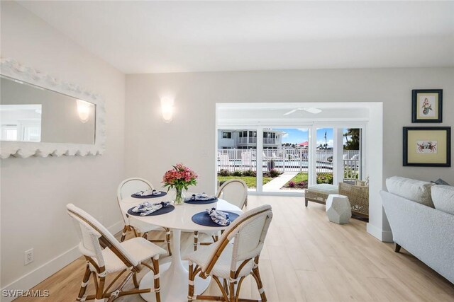 dining area featuring baseboards and light wood-type flooring
