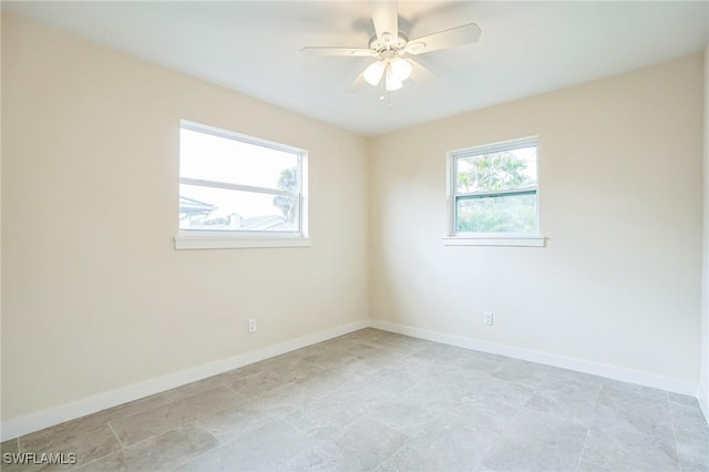 spare room featuring baseboards and a ceiling fan