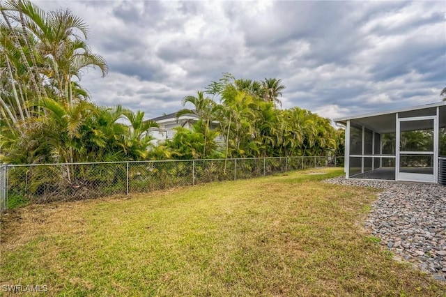 view of yard with fence and a sunroom