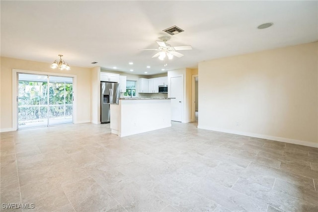 unfurnished living room featuring recessed lighting, visible vents, baseboards, and ceiling fan with notable chandelier