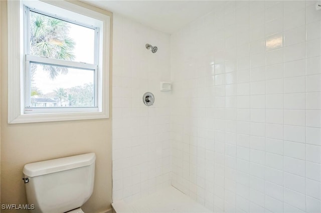 bathroom featuring toilet and tiled shower