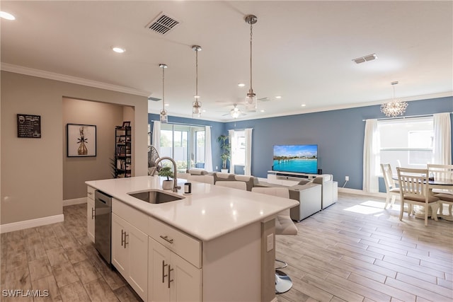 kitchen featuring stainless steel dishwasher, crown molding, visible vents, and a sink