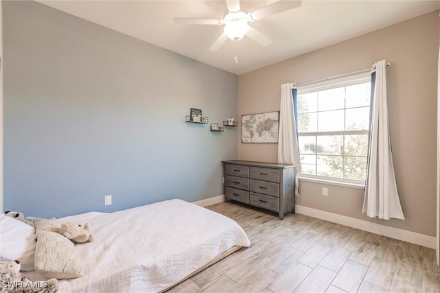 bedroom with a ceiling fan, baseboards, and wood finished floors