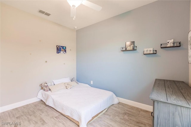 bedroom featuring visible vents, baseboards, and wood finished floors