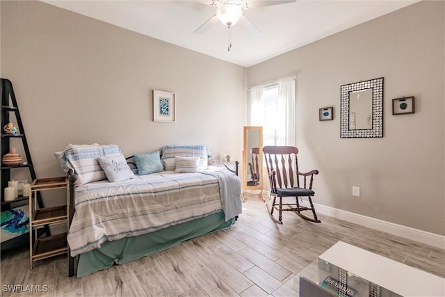 bedroom featuring a ceiling fan, baseboards, and wood finished floors