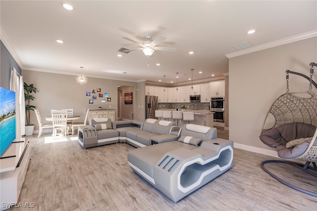 living room with light wood-style flooring, ceiling fan with notable chandelier, and crown molding