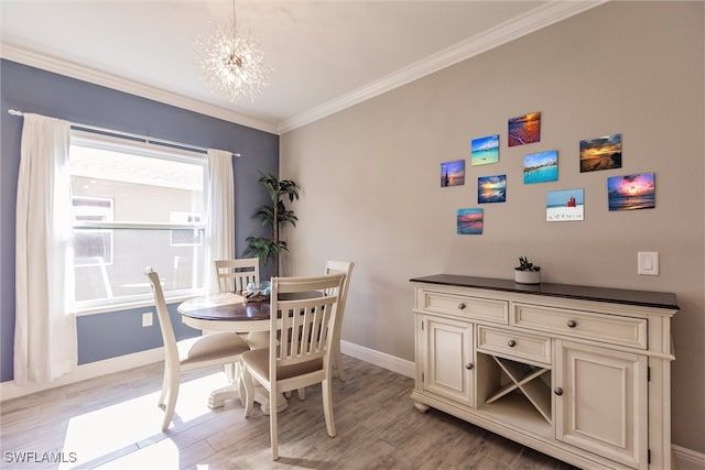 dining space with crown molding, a notable chandelier, baseboards, and light wood finished floors