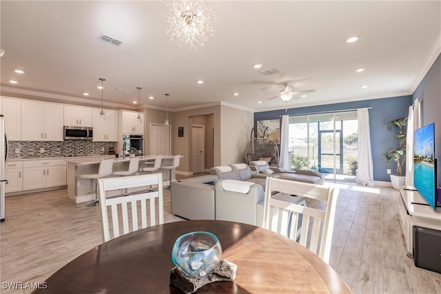 dining room featuring a ceiling fan, visible vents, recessed lighting, crown molding, and light wood-type flooring